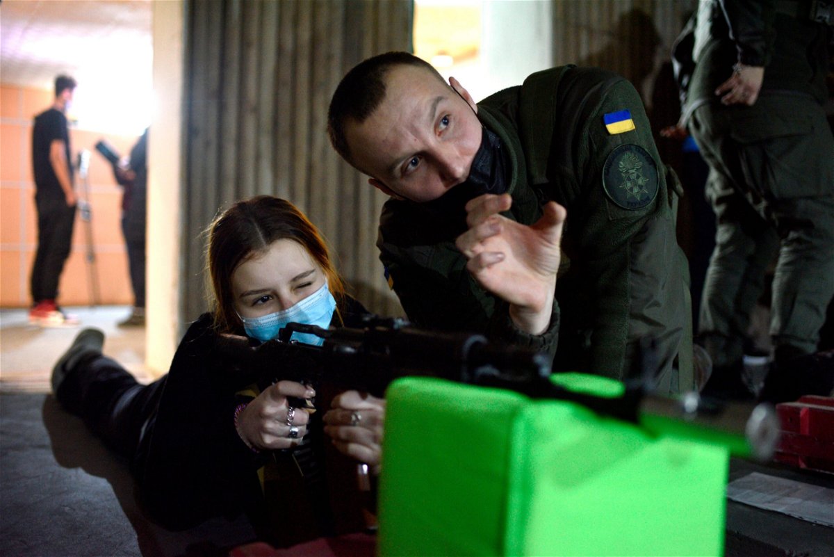 <i>Markiian Lyseiko/Ukrinform/Future Publishing/Getty Images</i><br/>A young volunteer aims at a target during the shooting exercises for high school students.