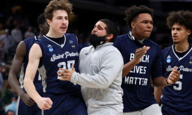 Saint Peter's Peacocks guard Doug Edert (L) celebrates after making a three-pointer against the Kentucky Wildcats on March 17. The Peacocks stunned the Wildcats during the first round of March Madness.