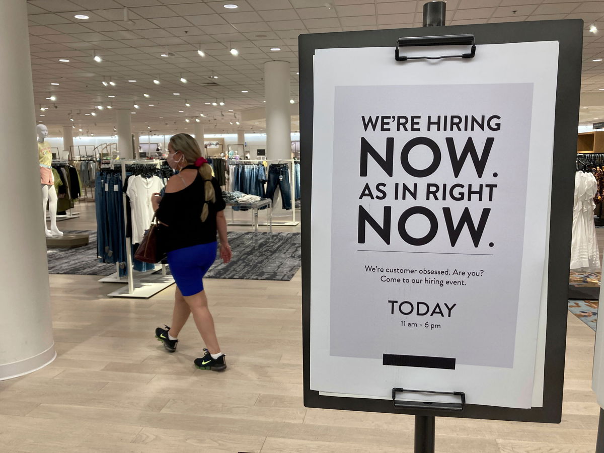 <i>Marta Lavandier/AP</i><br/>A customer walks behind a sign at a Nordstrom store seeking employees in Coral Gables
