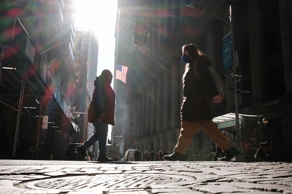 <i>Spencer Platt/Getty Images</i><br/>People walk along Wall Street near the New York Stock Exchange (NYSE) on March 11 in New York City. Surging oil and gas prices have raised recession alarm bells around the world. But another economic indicator is starting to look ominous: The yield curve is flattening.