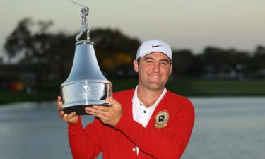 Scottie Scheffler poses with the trophy after winning the Arnold Palmer Invitational.