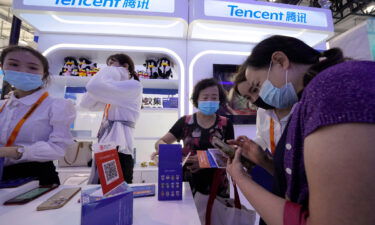 A woman is seen at the Tencent booth during a trade-in services fair in Beijing in September 2021. Stocks for the Chinese social media and gaming company Tencent