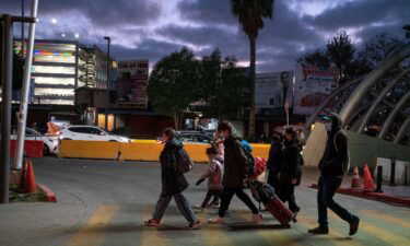 Ukrainian citizens walk along with advocates on the Mexican side of the border on March 9