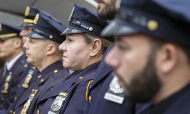 A female police officer stands with her male police department colleagues in New York City.