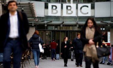 The BBC said that it had no choice but to "temporarily suspend the work" of its journalists and staff in Russia. Pedestrians are shown here walking past a BBC logo at Broadcasting House in London