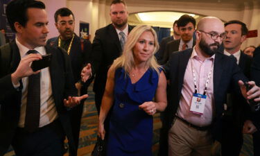 Rep. Marjorie Taylor Greene (R-GA) is escorted through a throng of media as she attends the CPAC on February 26 in Orlando