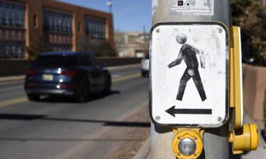 Pictured is a pedestrian crosswalk button at an intersection in Santa Fe