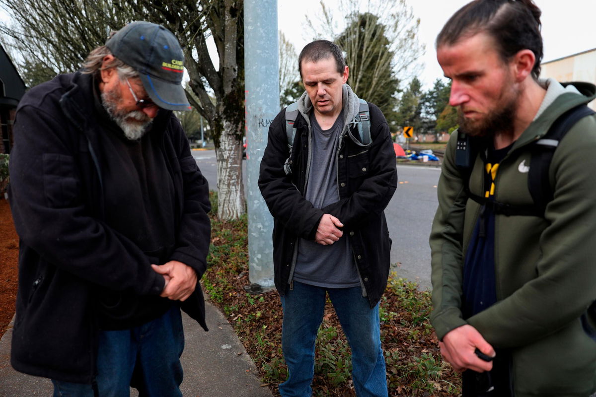 <i>Abigail Dollins/Statesman-Journal/AP</i><br/>Community members pray for the victims of a car crash that left four people dead at a homeless camp in Salem