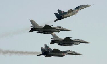 Two Polish Air Force Russian-made MiG-29's fly above and below two Polish Air Force US-made F-16's fighter jets during the Air Show in Radom