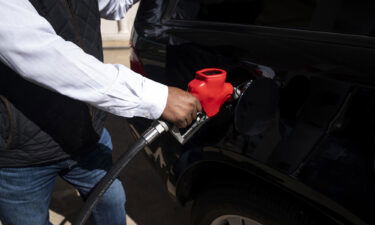 A man pumps gas at an Exxon station in Washington on March 8. Many Americans are struggling to accommodate the swift and sudden rise in gas prices into their family budgets.