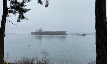 Navy tug boats support the ex-USS Kitty Hawk's in its final transit from Naval Base Kitsap-Bremerton