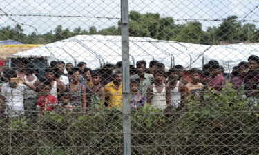 Rohingya refugees gather near a fence during a government organized media tour