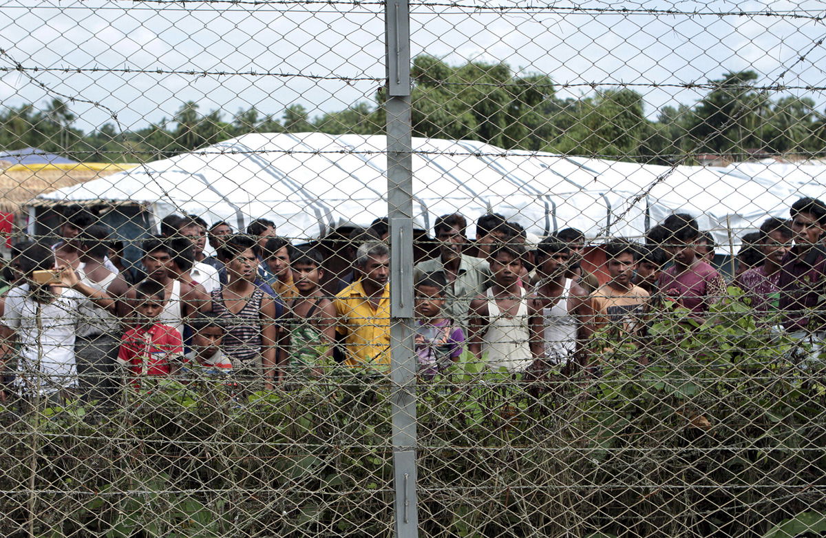 <i>Min Kyi Thein/AP</i><br/>Rohingya refugees gather near a fence during a government organized media tour