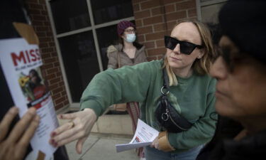 Lindsay Doyle and Alexis Martinez post fliers for missing activist Elise Malary on March 17. The body of a woman found in Lake Michigan on March 17 has been identified as missing transgender rights advocate Elise Malary