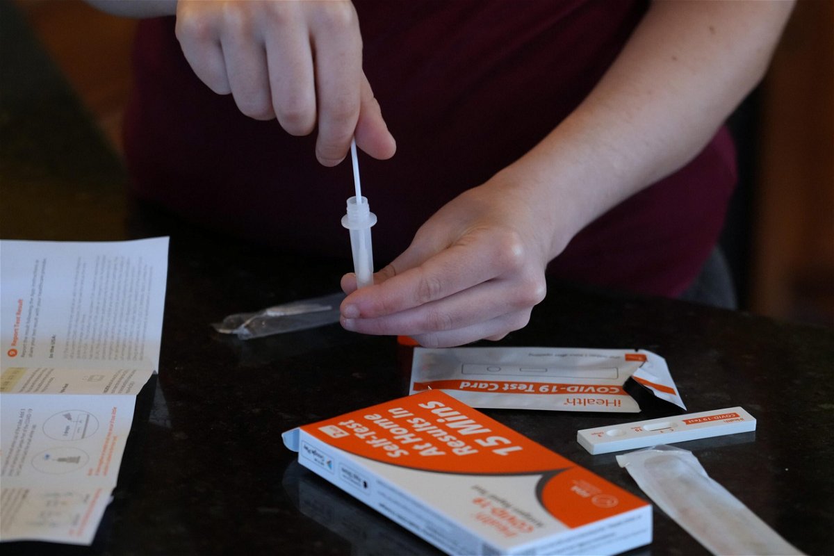 <i>George Frey/Getty Images</i><br/>A Walmart worker processes a nasal swab in one of the new government-issued COVID-19 Antigen Rapid test kits she received as she self tests while at home on February 8