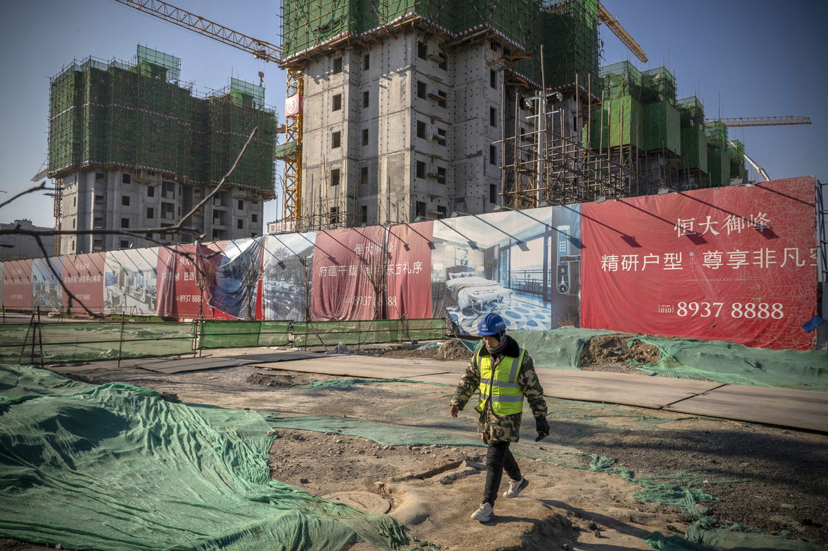 <i>Andrea Verdelli/Bloomberg/Getty Images</i><br/>A worker walks past unfinished apartment buildings at the construction site of a China Evergrande Group development in Beijing