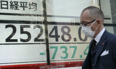 A pedestrian walks past an electronic share price board showing the numbers on the Tokyo Stock Exchange in Tokyo on March 7.