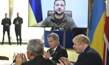 British Prime Minister Boris Johnson and attendees applaud after Ukraine's President Volodymyr Zelensky addressed a meeting of the Joint Expeditionary Force in London on March 15. Zelensky signals he doesn't expect Ukraine to join NATO anytime soon.