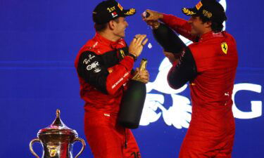 Leclerc and Carlos Sainz celebrate on the podium after securing a Ferrari one-two.