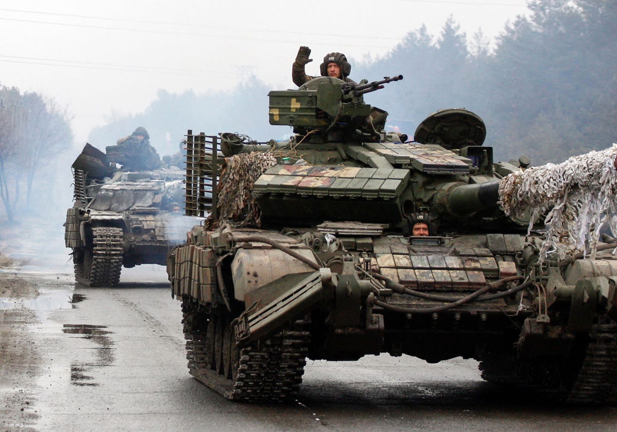 <i>Anatolii Stepanov/AFP/Getty Images</i><br/>Ukrainian servicemen ride on tanks towards the front line with Russian forces in the Lugansk region of Ukraine in February.