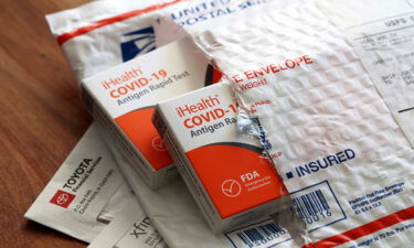 Free iHealth COVID-19 antigen rapid tests from the federal government sit on a U.S. Postal Service envelope after being delivered on February 04