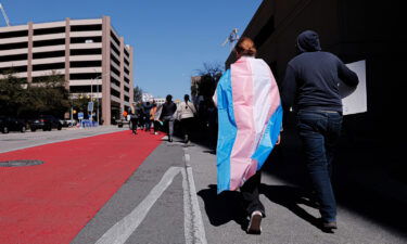 Dylan Yeary (L) wears the trans flag during a rally for trans rights in Austin