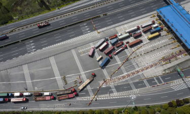 Trucks pass through a checkpoint on a highway leading from Shanghai