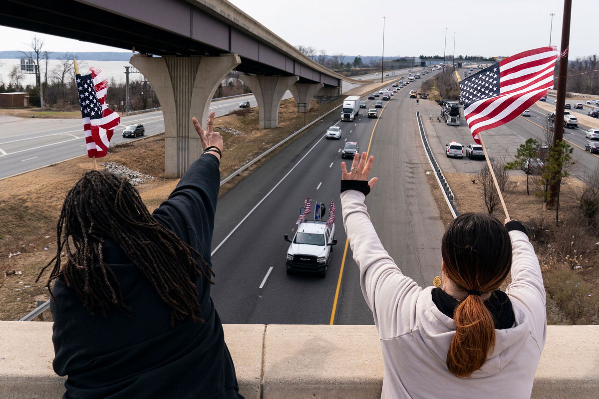 <i>Alex Brandon/AP</i><br/>Supporters wave as a convoy of trucks and other vehicles travel I-495 near the Woodrow Wilson Bridge