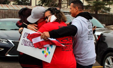 George DeJesus is embraced by family and supporters on March 22 at a restaurant in Lansing