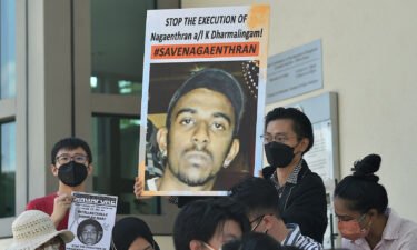 Activists hold posters displaying messages against the execution of Nagaenthran K. Dharmalingam