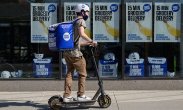 An employee rides a scooter to deliver groceries from 'Fridge No More' on March 31