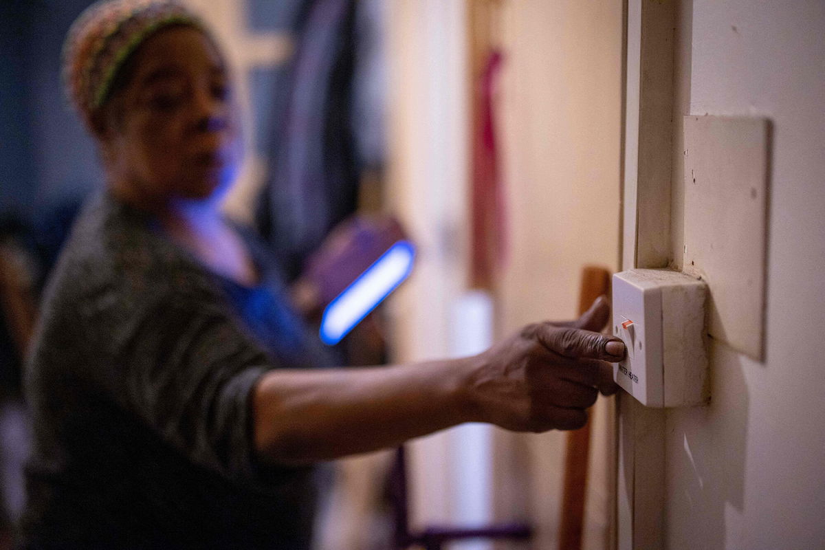 <i>Tolga Akmen/AFP/Getty Images</i><br/>Doreen Thompson turns off her water heater to keep up with her increasing energy bills at her home in south London in November 2021. The UK government is cutting taxes on wages and fuel as inflation soars.