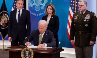 U.S. President Joe Biden signs legislative action to provide security aid and support to Ukraine as Secretary of State Antony Blinken (L)