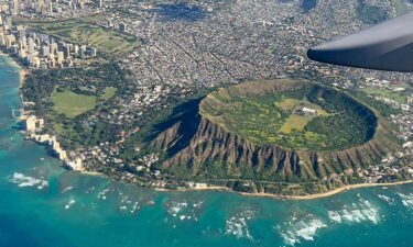 An aerial view from the window of a plane shows Diamond Head crater in Oahu