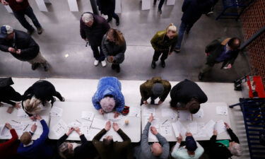 Caucusgoers check in at a caucus at Roosevelt Hight School on February 3