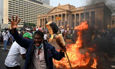 An opposition activist shouts slogans holding up bread as he protests along with others against rising living costs