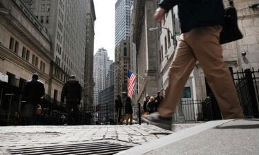 People walk by the New York Stock Exchange (NYSE) on April 4