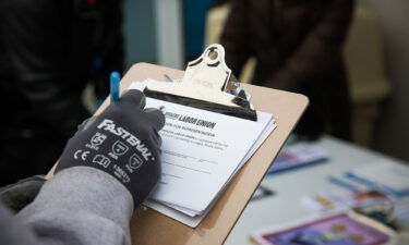 An Amazon employee signs a labor union authorization for representation form outside the Amazon LDJ5 fulfillment center in the Staten Island borough of New York