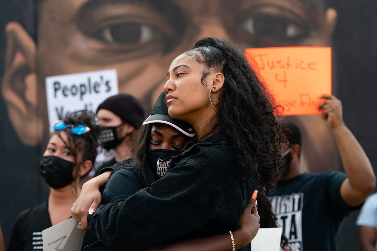 <i>Elijah Nouvelage/AFP/Getty Images</i><br/>Two women embrace in front of a mural of George Floyd following the guilty verdict the trial of Derek Chauvin on April 20