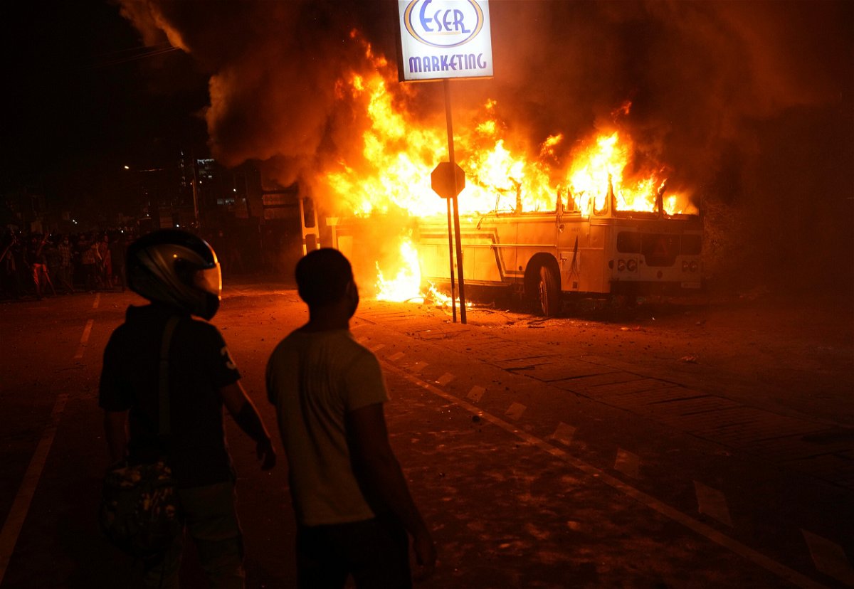 <i>Eranga Jayawardena/AP</i><br/>Sri Lankans watch a bus on fire during a protest outside the President's private residence on the outskirts of Colombo