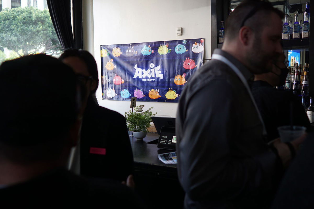 <i>Jon Sarlin/CNN</i><br/>An Axie Infinity poster hangs at a meet-up in Los Angeles