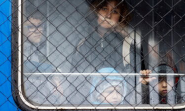 Ukrainian refugees look out of a train from Odesa at Przemysl Glowny train station