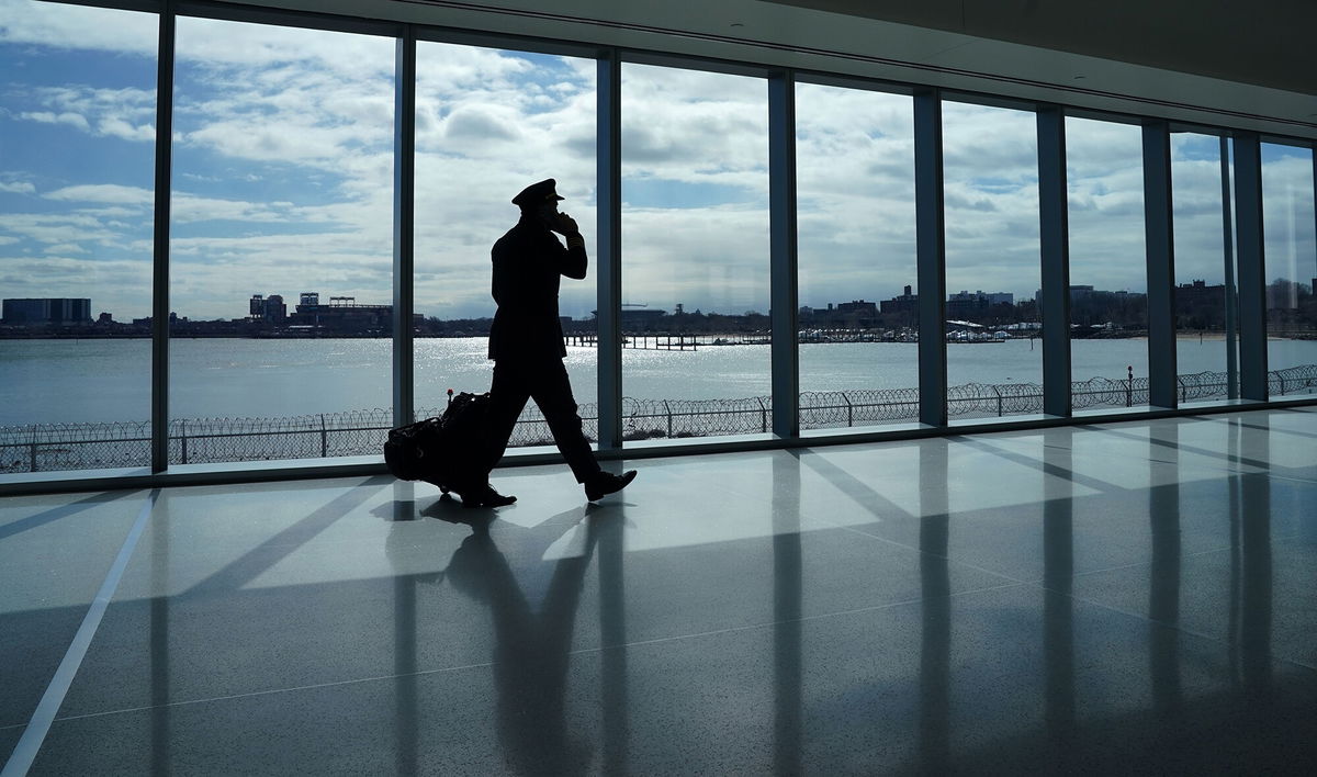 <i>Timothy A. Clary/AFP/Getty Images</i><br/>A pilot walks past the windows at the newly renovated Delta terminal D at LaGuardia Airport in New York March 6