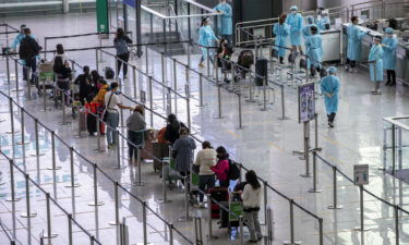 Travelers heading to quarantine in the arrival hall at Hong Kong International Airport in Hong Kong