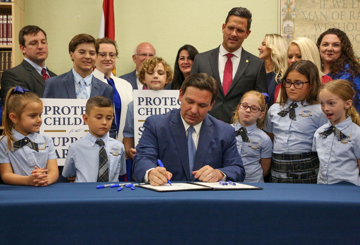 <i>Douglas R. Clifford/Tampa Bay Times/AP</i><br/>Florida Gov. Ron DeSantis signs the Parental Rights in Education bill at Classical Preparatory school Monday