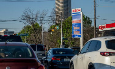 Cars drive past an Exxon gas station on April 01