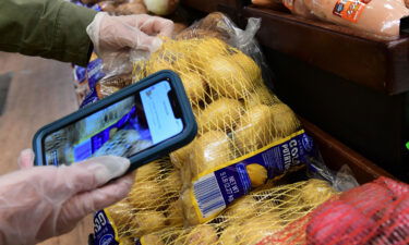 An Instacart employee uses her cellphone to scan barcodes showing proof of purchase for the customer while picking up groceries from a supermarket for delivery on March 19