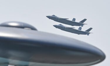 Two J-20 stealth fighter jets perform in the sky during an airshow in Zhuhai