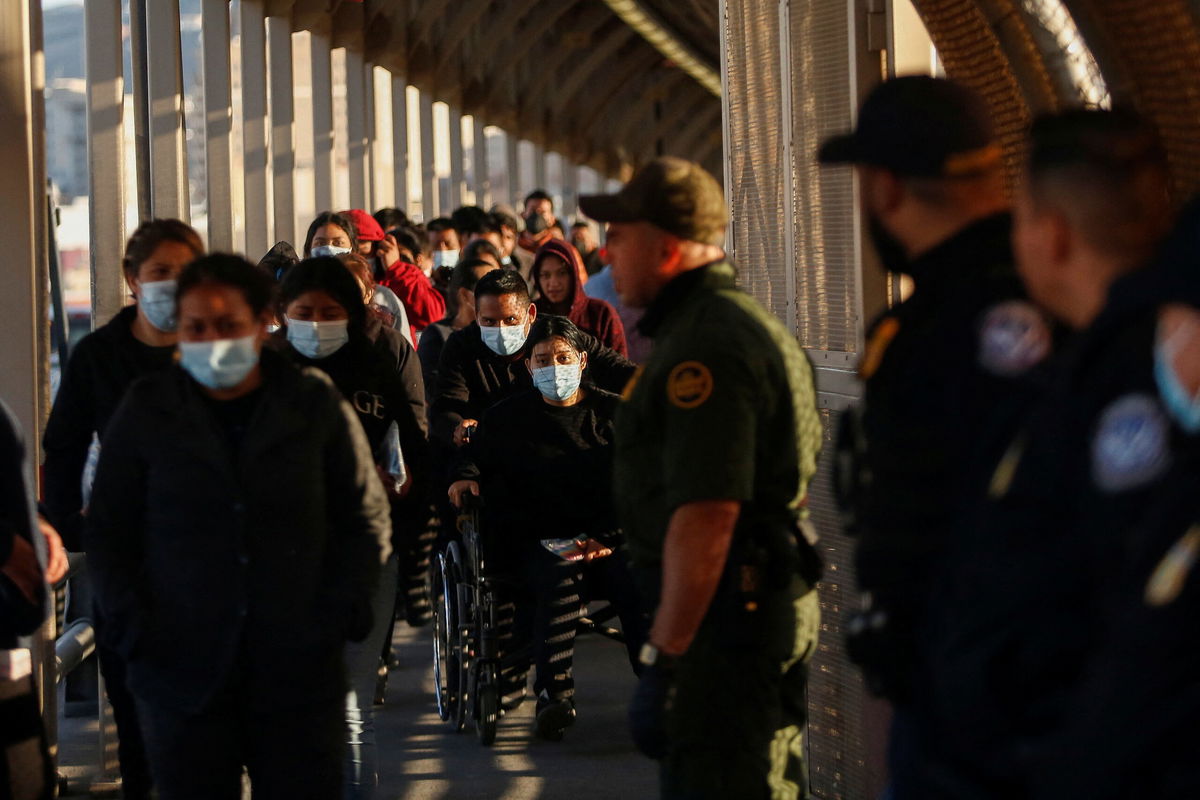 <i>Jose Luis Gonzalez/Reuters</i><br/>Migrants expelled from the US and sent back to Mexico under Title 42 walk towards Mexico at the Paso del Norte International border bridge on April 1.