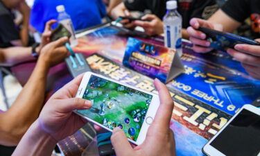 A Chinese player competes in a match of Tencent's mobile MOBA "King of Glory" or "Honor of Kings" on his smartphone during the 3rd Yangtze River Three Gorges E-sports Games (TGEG) in Chongqing